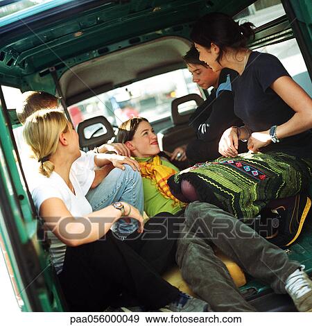 Stock Photo - Group of teenagers sitting in back of van. Fotosearch