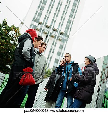 Stock Photo - Group of young people outside, highrise in background. Fotosearch