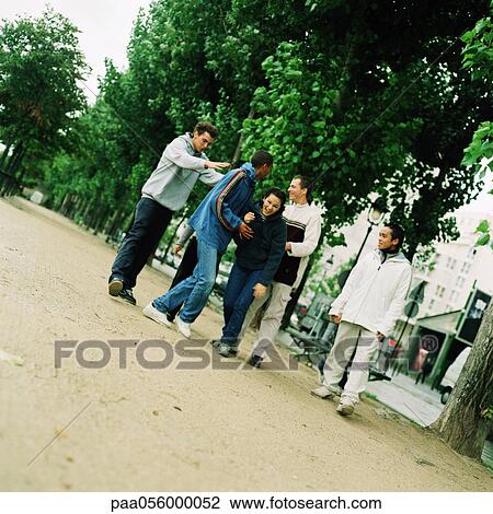 Stock Image - Group of young people walking in park. Fotosearch