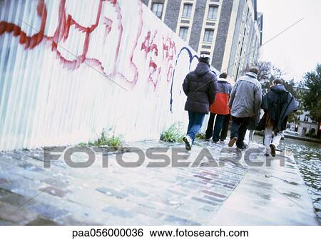 Stock Photograph - Group of young people walking in street, rear view. Fotosearch