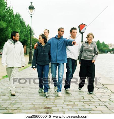 Six young people walking together on cobblestones View Large Photo Image Stock Photography - Six young people walking together on cobblestones. Fotosearch