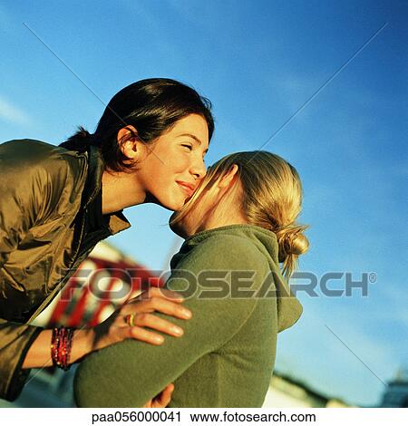 Teenage Girls Kissing Cheeks Stock Image Paa Fotosearch