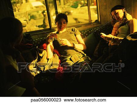Stock Image - Teenage girls sitting in room. Fotosearch