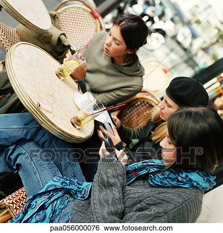 Three teenagers sitting at cafe terrace View Large Photo Image Stock Photograph - Three teenagers sitting at cafe terrace. Fotosearch