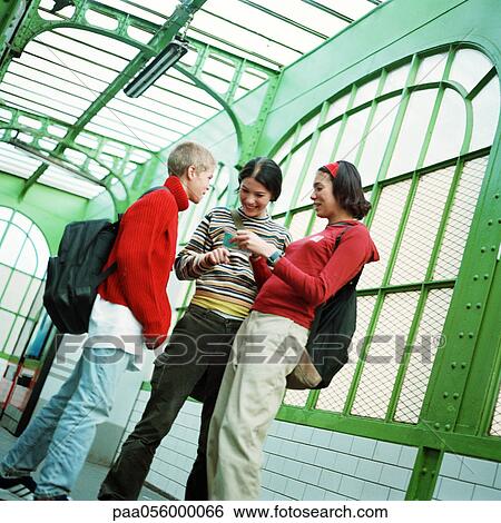 Three teenagers standing in subway station View Large Photo Image Stock Photograph - Three teenagers standing in subway station. Fotosearch