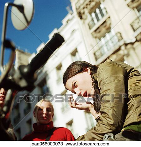 Stock Image - Two teenage girls in street, low angle view. Fotosearch