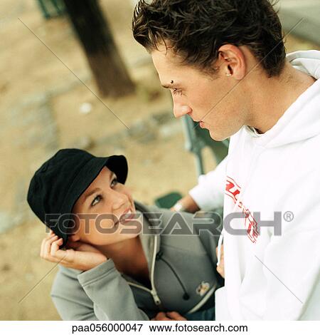 Stock Photo - Young couple, girl smiling, high angle view. Fotosearch