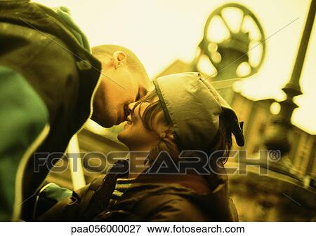 Young couple kissing, blurred background View Large Photo Image Stock Photo - Young couple kissing, blurred background. Fotosearch