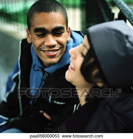 Stock Image - Young couple side by side, smiling. Fotosearch