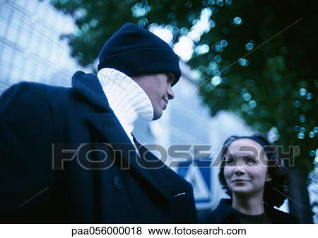 Young man and woman in street, low angle view View Large Photo Image Stock Photo - Young man and woman in street, low angle view. Fotosearch
