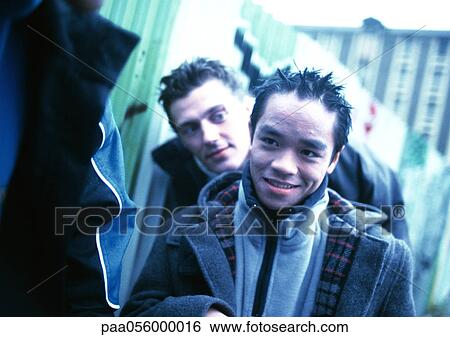 Young men, outside, building in background View Large Photo Image Stock Photograph - Young men, outside, building in background. Fotosearch