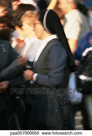 Stock Photography - Nun, side view, crowd in background, blurred. Fotosearch