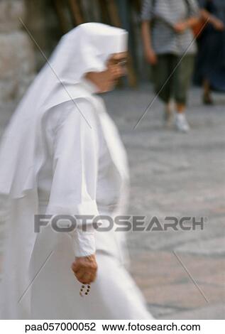 Nun walking in street, side view View Large Photo Image Stock Image - Nun walking in street, side view. Fotosearch