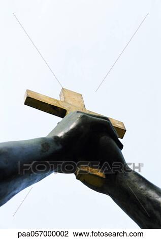Statue, hands holding crucifix, low angle view View Large Photo Image Stock Image - Statue, hands holding crucifix, low angle view. Fotosearch