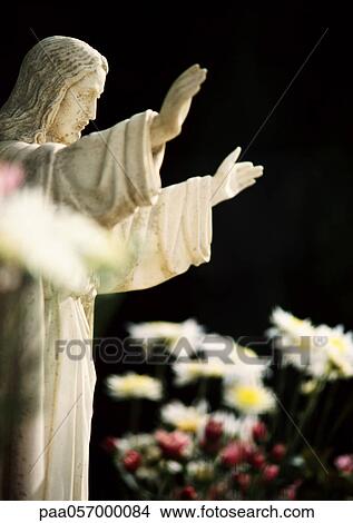 Statue of Christ, side view, flowers in foreground View Large Photo Image Picture - Statue of Christ, side view, flowers in foreground. Fotosearch