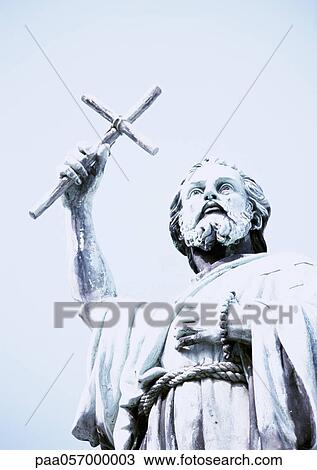 Statue of man holding crucifix, low angle view View Large Photo Image Stock Image - Statue of man holding crucifix, low angle view. Fotosearch