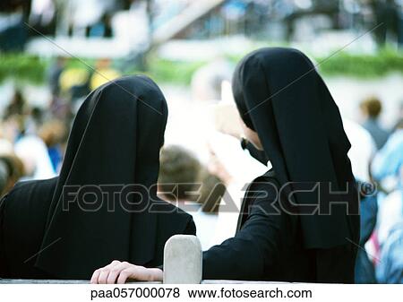 Two nuns standing side by side, overlooking crowd, rear view View Large Photo Image Stock Photo - Two nuns standing side by side, overlooking crowd, rear view. Fotosearch