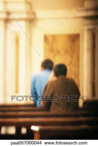 Two people praying in church, rear view, blurred View Large Photo Image Picture - Two people praying in church, rear view, blurred. Fotosearch