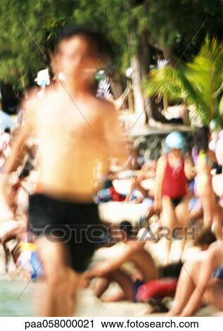 Bare-chested person running, people in background on beach, blurred View Large Photo Image Stock Image - Bare-chested person running, people in background on beach, blurred. Fotosearch