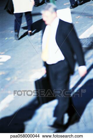 Picture - Businessman walking in street, blurred. Fotosearch