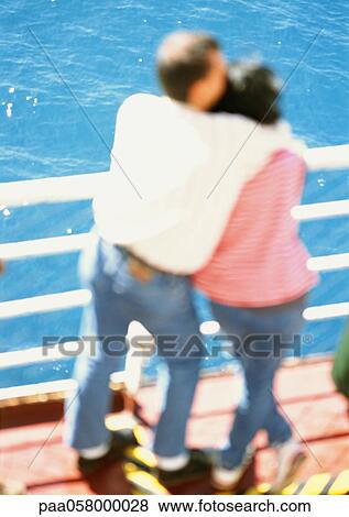 Couple hugging, looking out to sea, blurred View Large Photo Image Stock Photo - Couple hugging, looking out to sea, blurred. Fotosearch