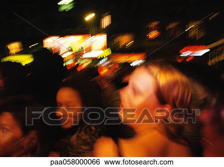 Stock Photograph - Crowd at night, blurred. Fotosearch