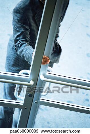Stock Image - Man opening door, partial view, high angle view. Fotosearch