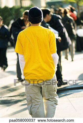 Stock Photo - Man walking in street, rear view. Fotosearch