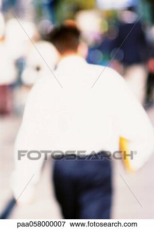 Stock Photo - Man walking, rear view, blurred. Fotosearch