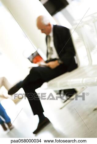Mature man sitting on bench, reading, blurred View Large Photo Image Picture - Mature man sitting on bench, reading, blurred. Fotosearch