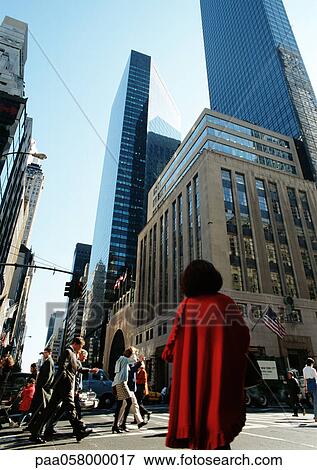 Stock Photo - People in street, skyscrapers in background, low angle view. Fotosearch