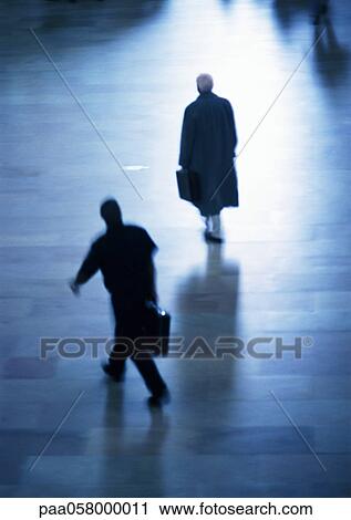 Stock Image - Two people walking, high angle view, blurred. Fotosearch