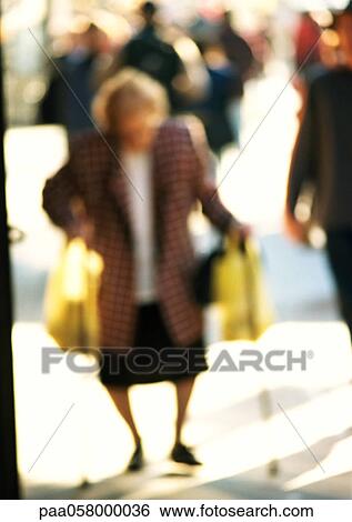 Woman carrying bags in street, blurred View Large Photo Image Stock Photograph - Woman carrying bags in street, blurred. Fotosearch