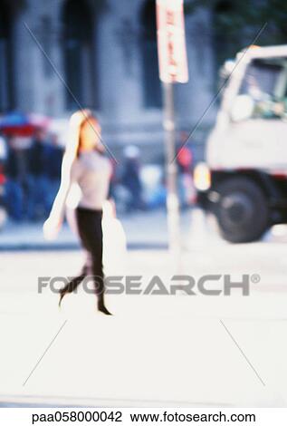 Woman holding bag, walking in street, blurred View Large Photo Image Stock Image - Woman holding bag, walking in street, blurred. Fotosearch