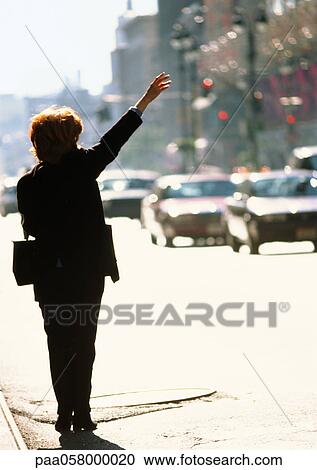 Stock Image - Woman in street, raising arm. Fotosearch