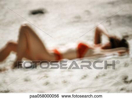 Woman in swimming suit, lying on sand, blurred View Large Photo Image Stock Photograph - Woman in swimming suit, lying on sand, blurred. Fotosearch