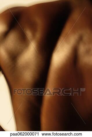 Stock Image - Man's bare back, close up, blurred. Fotosearch