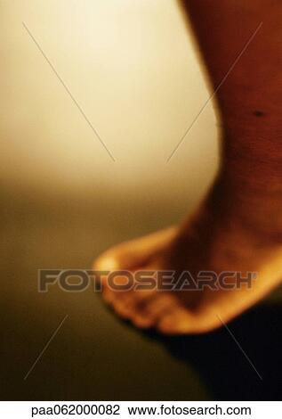 Stock Image - Man's bare foot, close up, blurred. Fotosearch