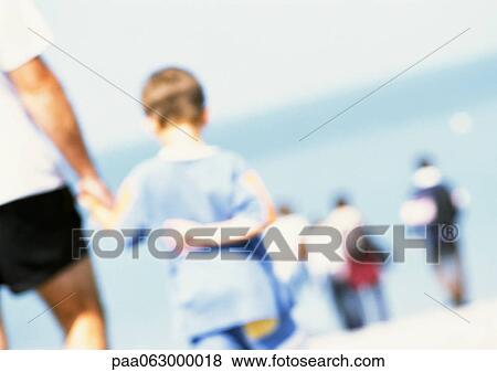 Adult and child holding hands on beach, rear view, people in distance, blurred View Large Photo Image Stock Photo - Adult and child holding hands on beach, rear view, people in distance, blurred. Fotosearch