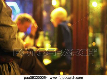 Picture - Couple sitting at table in cafe, blurred. Fotosearch