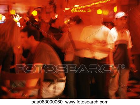 Stock Image - Crowd of people in night club, blurred motion. Fotosearch