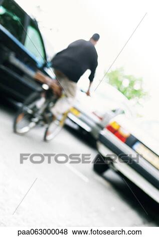 Stock Photo - Cyclist and cars, tilted, blurred. Fotosearch