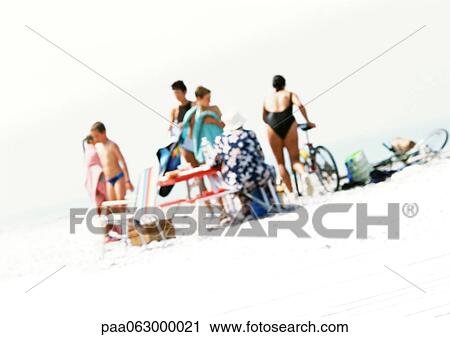 Stock Image - Group of people on beach, blurred. Fotosearch