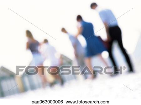 Stock Photograph - Group of people on beach, blurred. Fotosearch