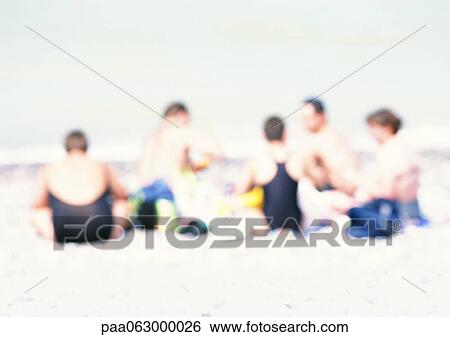 Group of people sitting on sand at the beach, blurred View Large Photo Image Stock Photograph - Group of people sitting on sand at the beach, blurred. Fotosearch