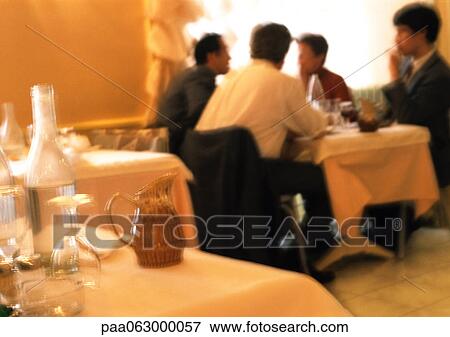 Stock Photo - People dining in restaurant, blurred.. Fotosearch