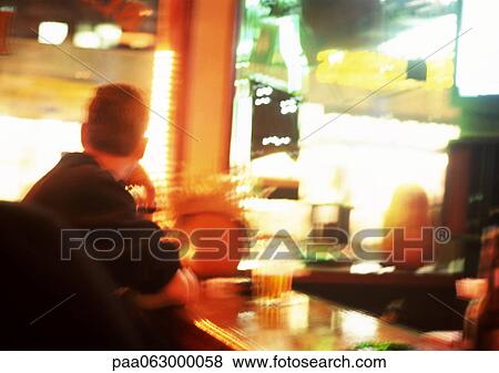 People sitting at table in restaurant, bright lights in background, blurred. View Large Photo Image Stock Photo - People sitting at table in restaurant, bright lights in background, blurred.. Fotosearch