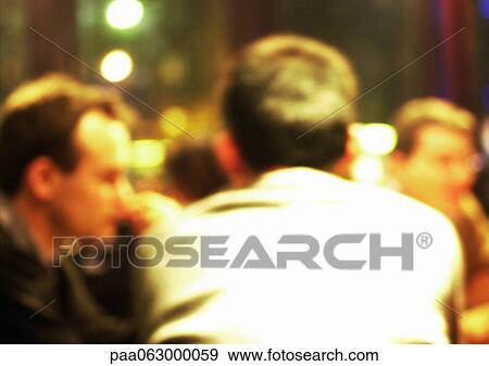 People sitting, one man with back towards camera, blurred. View Large Photo Image Stock Photo - People sitting, one man with back towards camera, blurred.. Fotosearch