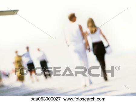 Stock Photo - People walking along at beach, blurred. Fotosearch