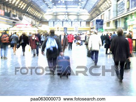 Stock Image - People walking in train station, blurred. Fotosearch